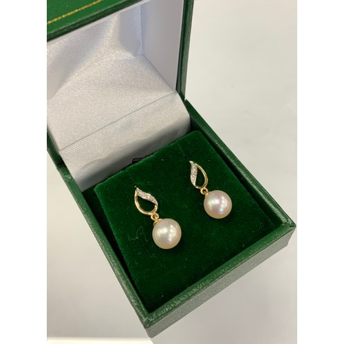 357 - A pair of diamond and cultured pearl drop earrings, diamond accented flame bales with creamy single ... 