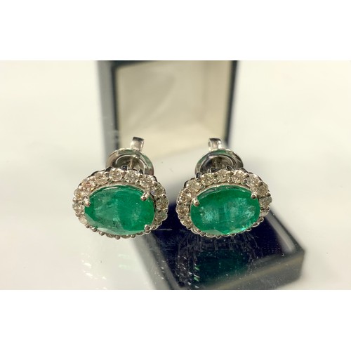 370 - A pair of emerald and diamond cluster earrings, each with a central oval emerald surrounded by eight... 