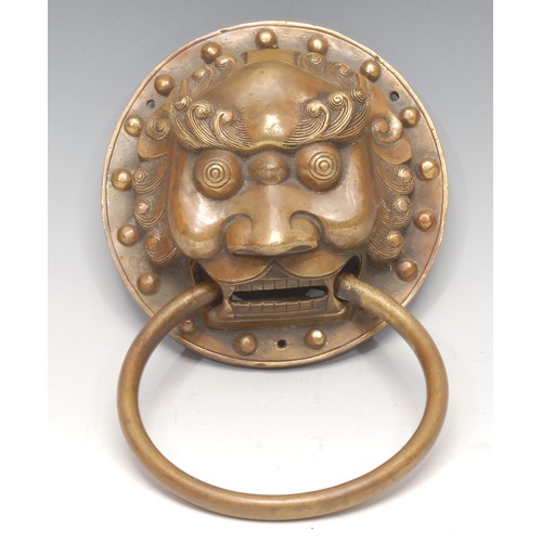 3174 - A substantial Chinese brass door knocker, cast as the head of a temple lion, 15cm diam