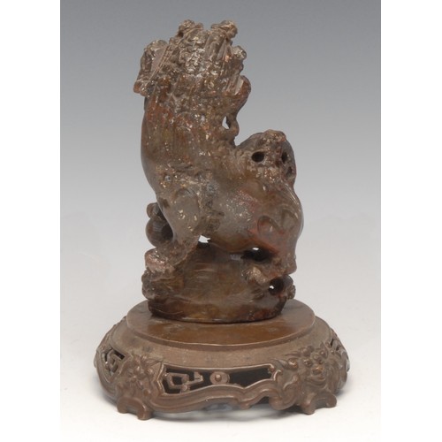 3076 - A Chinese soapstone carving, of a temple lion, bronze base, 18.5cm high