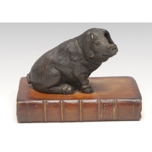 3293 - Interior Decoration - a cold cast desk model, of a dog, recumbent upon a leather bound book, 18.5cm ... 