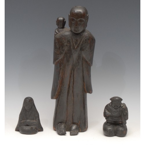 3067 - A Chinese carving, of Buddha and a child, standing, with serene expression, 36.5cm high; others (3)