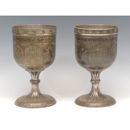 3160 - A pair of large Indian bidri pedestal goblets, each chased with stylised lotus, 21.5cm high