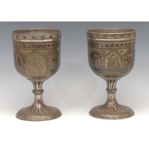 3160 - A pair of large Indian bidri pedestal goblets, each chased with stylised lotus, 21.5cm high