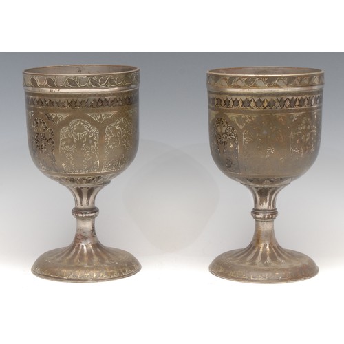 3160 - A pair of large Indian bidri pedestal goblets, each chased with stylised lotus, 21.5cm high