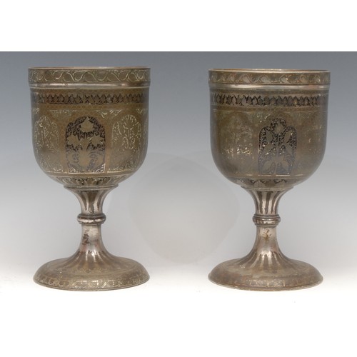 3160 - A pair of large Indian bidri pedestal goblets, each chased with stylised lotus, 21.5cm high