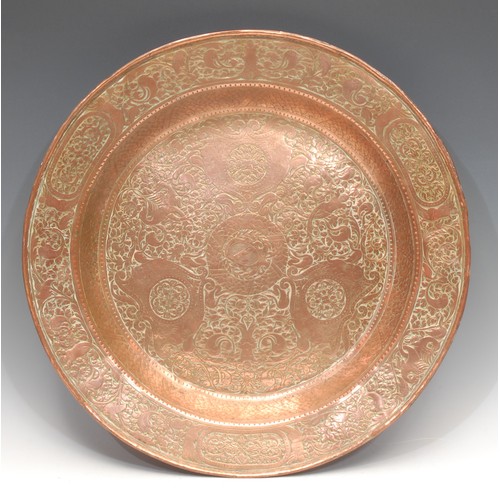 3163 - A Renaissance Revival copper rosewater dish, profusely chased and centred by an armorial, 46.5cm dia... 