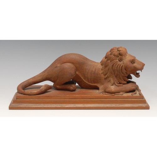 3204 - An early 20th century carving, of a lion and his kill, rectangular base, 29cm long