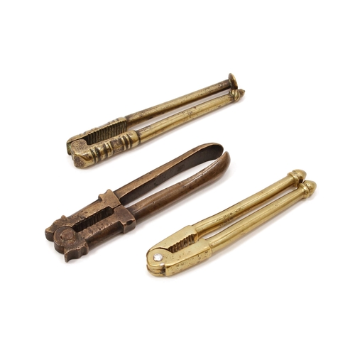 3556 - Nutcrackers - an 18th brass lever-action nut cracker, acorn and pipe tamper terminals, 10cm long; ot... 