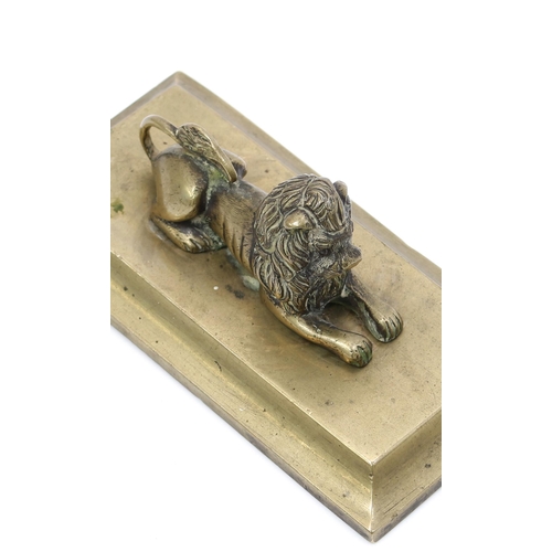 3162 - A Regency bronze desk weight, cast as a recumbent lion, spreading rectangular base, 13cm wide, c.182... 