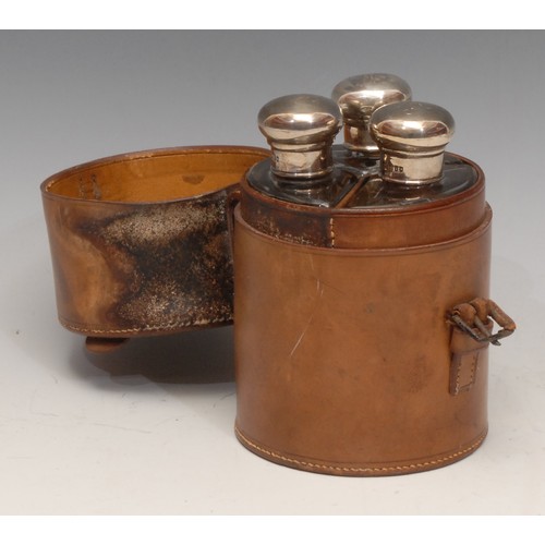 3168 - A set of three Edwardian silver mounted glass cologne bottles, leather cylindrical case, 14.5cm high... 