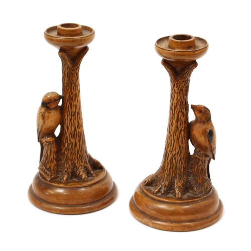 3154 - A pair of early 20th century sculptural walnut candlesticks, each carved with a woodpecker at a tree... 