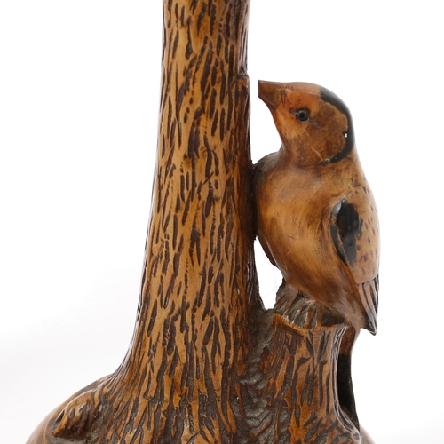 3154 - A pair of early 20th century sculptural walnut candlesticks, each carved with a woodpecker at a tree... 