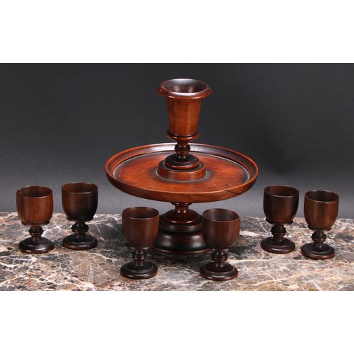 3349 - Treen - a George III turned pedestal egg cruet, with six egg cups, the stand 19cm diam, early 19th c... 