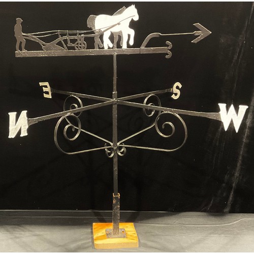 109 - A wrought iron weather vane, the steel pointer mounted with a silhouette of a ploughman and his cart... 