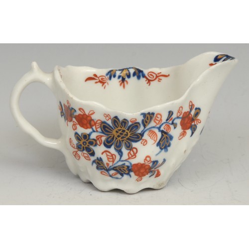 124 - A Lowestoft Low Chelsea ewer, decorated in underglaze blue and overglaze red with flowers and foliag... 