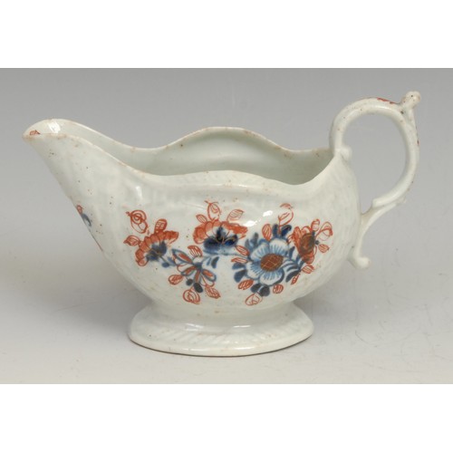 128 - A Liverpool cream boat, decorated in underglaze blue and overglaze red with flowers, picked out in g... 