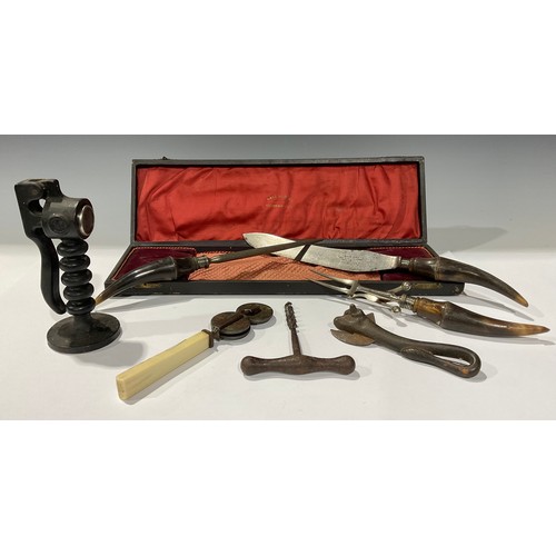 242 - A Victorian horn handled three piece carving set; a knife sharpener; and iron corkscrew; a bull tin ... 