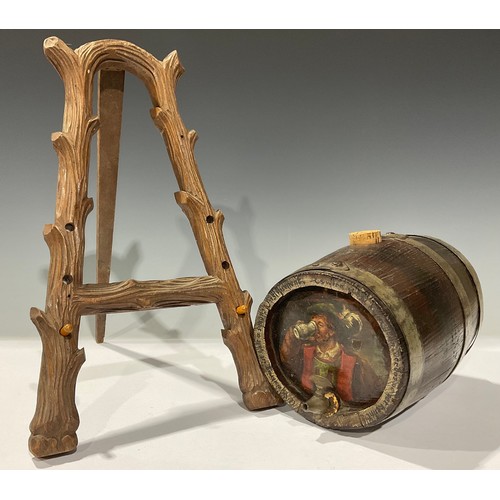 258 - A Black Forest display easel; a 19th century spirit barrel painted with man quaffing ale