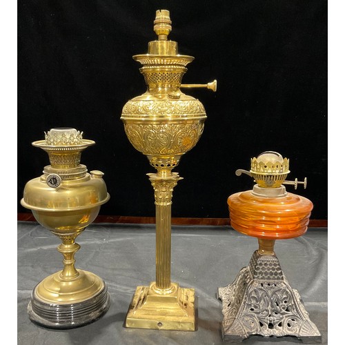 260 - A Corinthian column brass oil lamp; a brass oil lamp; an amber glass oil lamp