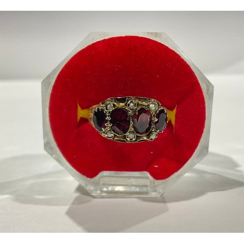 285 - A 19th century 9ct gold ring set with an arrangement of garnet and seed pearls, size O, marked 375, ... 