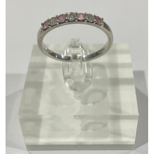 288 - A platinum engagement ring, set with three brilliant cut diamonds, interspersed with pink stones, si... 