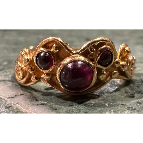 306 - An 18ct gold garnet ring, set with three circular cabochon red garnets, shaped scrolling crest, 18ct... 