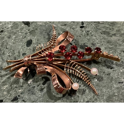 309 - A 9ct gold garnet and seed pearl brooch, cast as a spray of ribbon tied ferns and budding stems, the... 