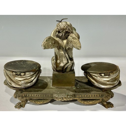 317 - A French silvered bronze inkstand, as an amorini flanked by drums, 19cm wide, early 20th century