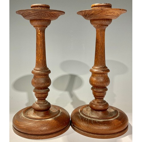 362 - Treen - a pair of turned oak candlesticks, detachable drip pans, 22cm high, early 20th century