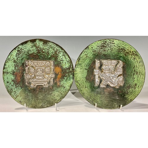 364 - A pair of South American silver mounted copper dishes, decorated in the pre-Columbian taste, Peru, m... 