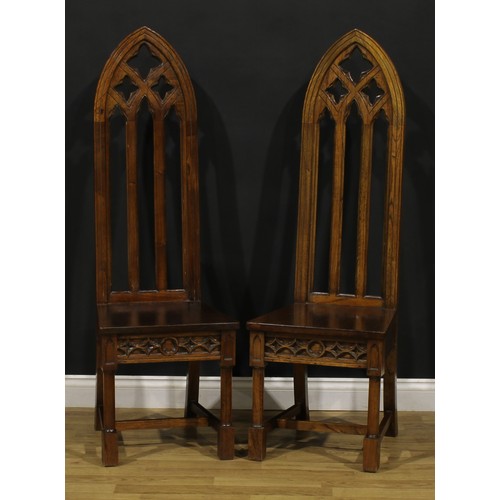 181 - A pair of contemporary Gothic Revival style hall chairs, each with a tall lancet-arched architectura... 