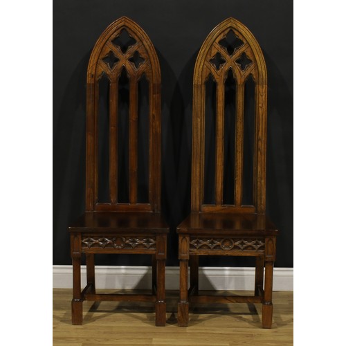 181 - A pair of contemporary Gothic Revival style hall chairs, each with a tall lancet-arched architectura... 