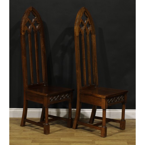 181 - A pair of contemporary Gothic Revival style hall chairs, each with a tall lancet-arched architectura... 