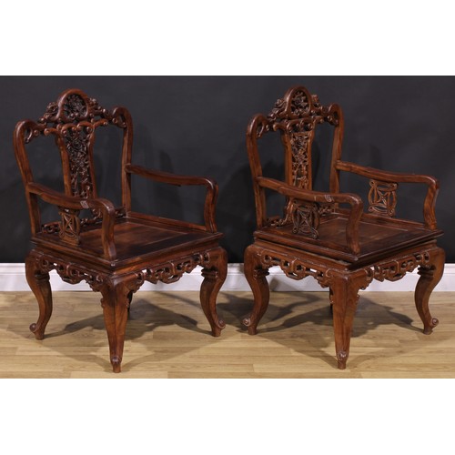 191 - A pair of Chinese hardwood armchairs, each with a shaped back pierced and carved with scrolls and fl... 