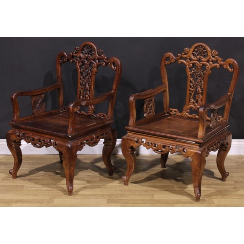 191 - A pair of Chinese hardwood armchairs, each with a shaped back pierced and carved with scrolls and fl... 