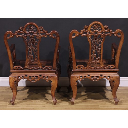 191 - A pair of Chinese hardwood armchairs, each with a shaped back pierced and carved with scrolls and fl... 