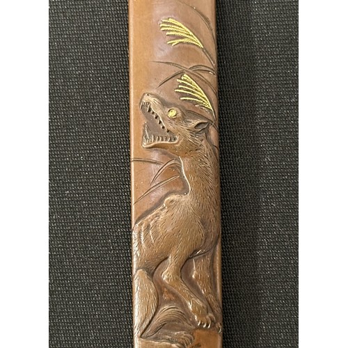 9104 - Japanese Kozuka knife handle featuring a Wolf, signed, 95mm in length. Complete with a wooden displa... 