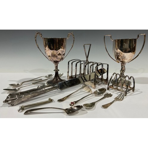 62 - A collection of silver teaspoons, Georgian and later, 97g; a plated toast rack; another; plated trop... 