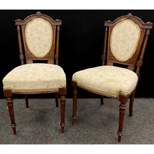 74 - A pair of Edwardian walnut bedroom chairs, carved and upholstered backs, turned and fluted legs;  a ... 