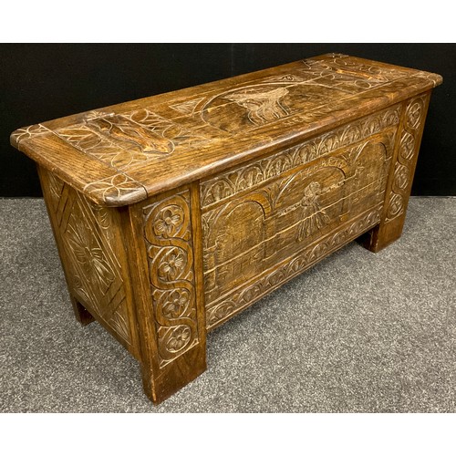 75 - A carved oak blanket chest/coffer, the lift-up lid caved with faux hinge straps, and portrait bust o... 