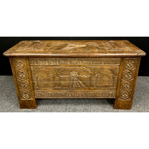 75 - A carved oak blanket chest/coffer, the lift-up lid caved with faux hinge straps, and portrait bust o... 