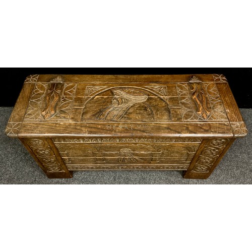 75 - A carved oak blanket chest/coffer, the lift-up lid caved with faux hinge straps, and portrait bust o... 