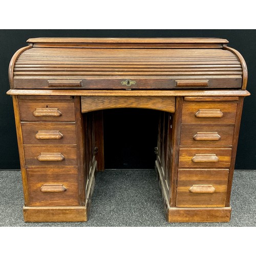 81 - An early to mid 20th century oak roll-top desk, the tambour roll-top enclosing a fitted interior, ab... 