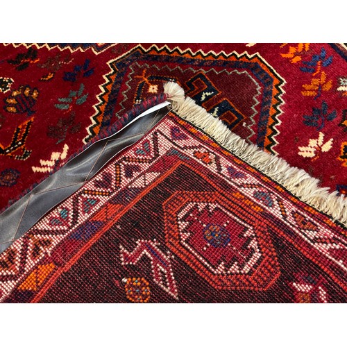 209 - A South West Persian Qashqai runner carpet, hand-knotted in rich tones of red, black, blue, and oran... 