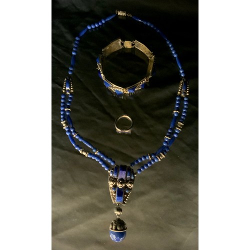 307 - An African lapis lazuli effect blue bead and silver coloured metal necklace, bracelet and ring suite... 