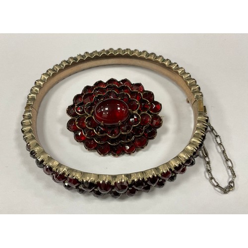 362 - A Victorian garnet and rose metal mounted hinge bangle, similar oval stacked cluster flowerhead broo... 