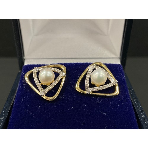 379 - A pair of rounded triangular diamond and cultured pearl earrings, central creamy white cultured pear... 