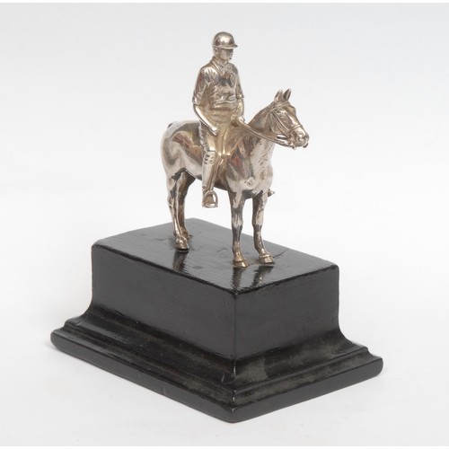 57 - A George V silver equestrian model, cast as a polo player on horseback, ebonised base, 14cm high ove... 