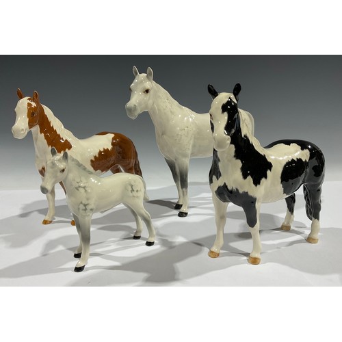 698 - A Beswick horse, Grey stallion and foal; a Beswick horse, piebald; another Shewbald (4)